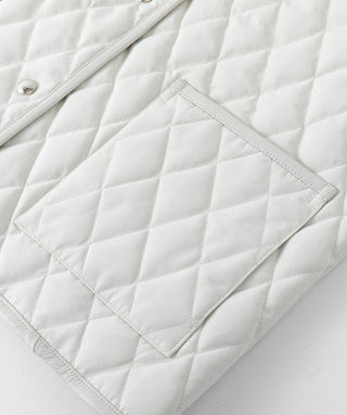 Light greige quilted fabric detail with diamond stitching and curved panel seams