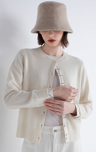 Light beige cashmere cardigan close-up: button placket and plaid layered cuffs