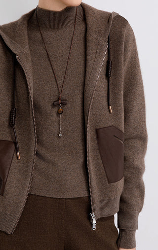 Close-up of brown wool-cashmere hooded jacket with front zip, drawcord, and leather pocket panel