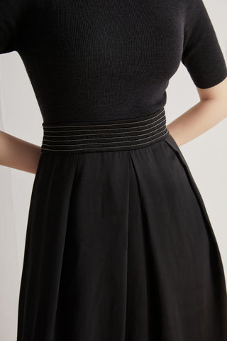 Close-up of black beaded waist detail on wool-silk midi dress with ribbed top